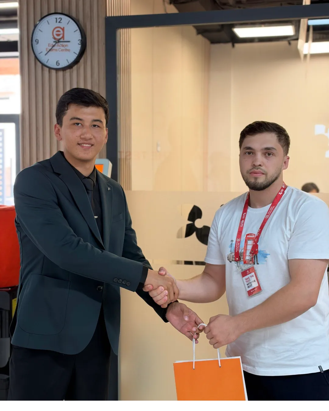 A REAL EXAMS representative and a member of staff shaking hands at Edu-Action Exams Centre.