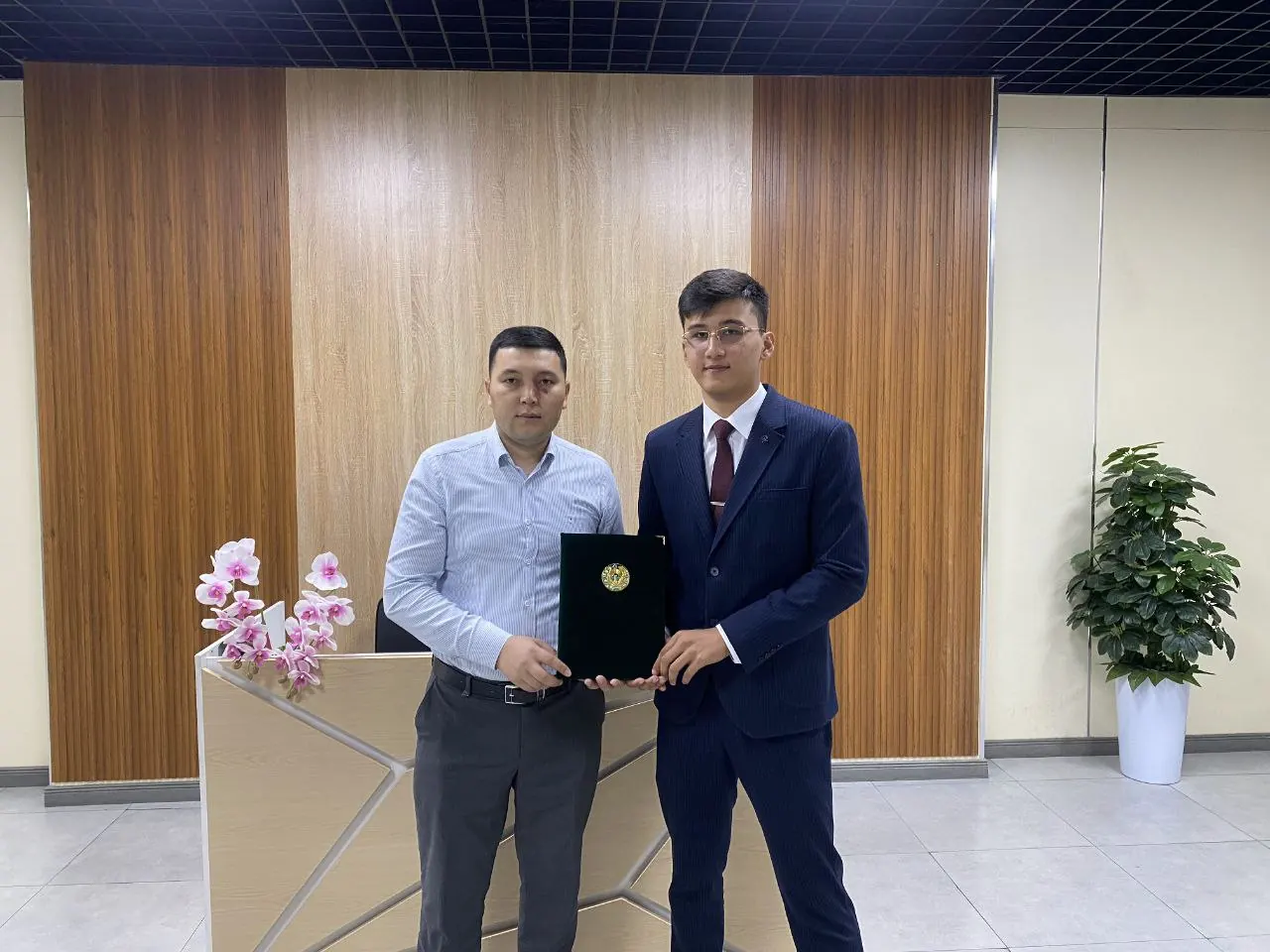 REAL EXAMS and Registan LC representatives holding the signed agreement.